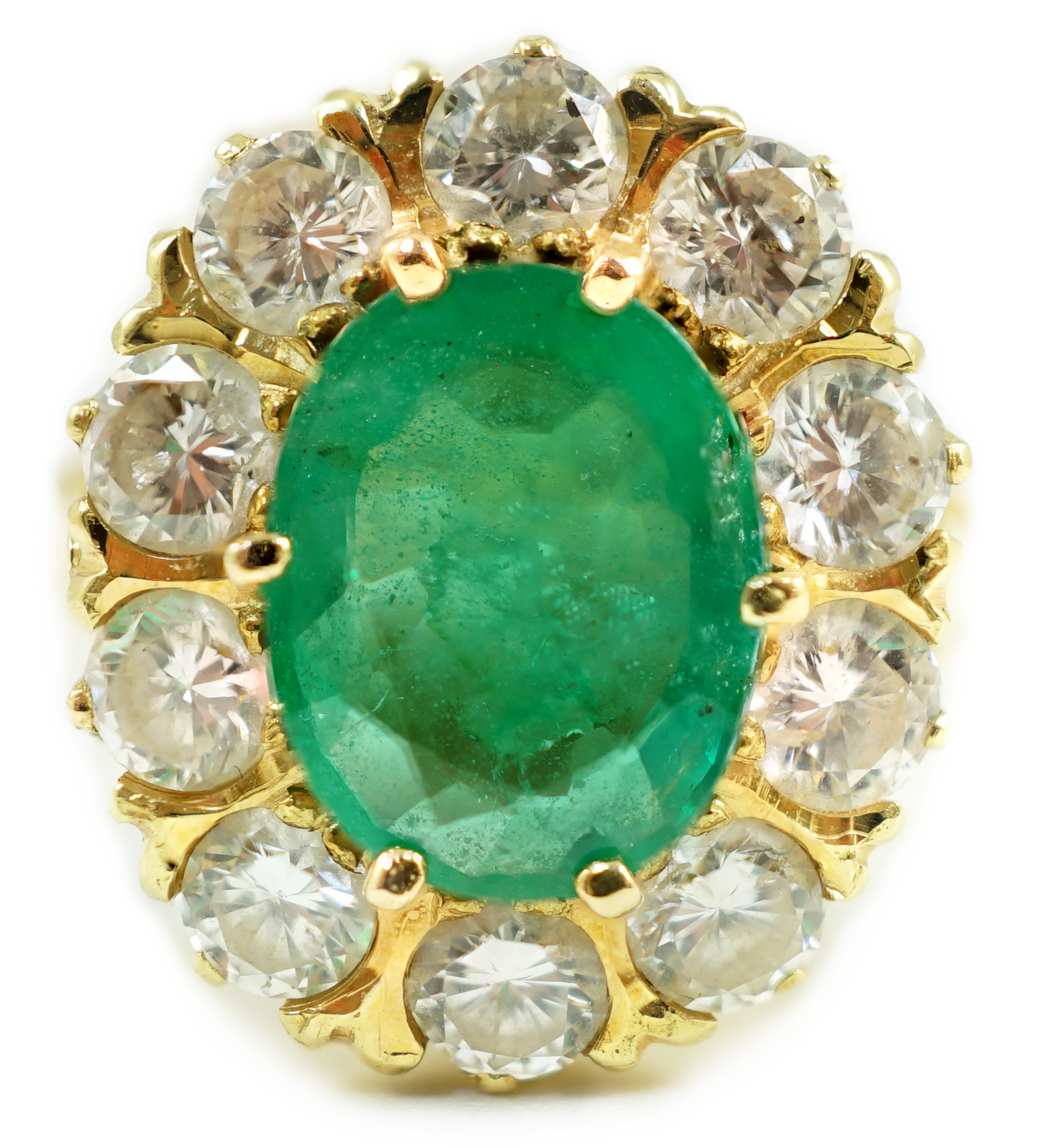 A modern 18ct gold, emerald and diamond set oval cluster ring